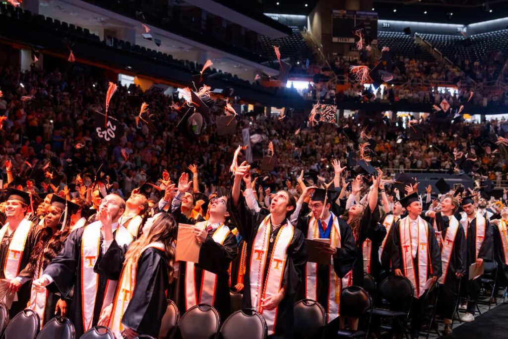 students tossing caps in air at graduation