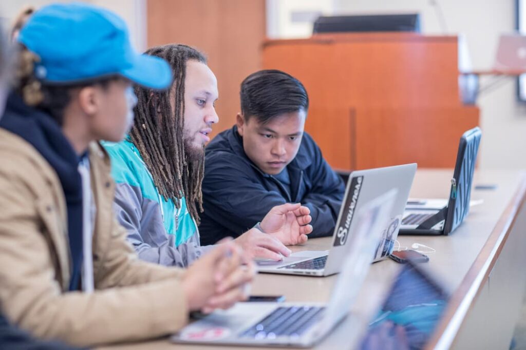 three students working computers together